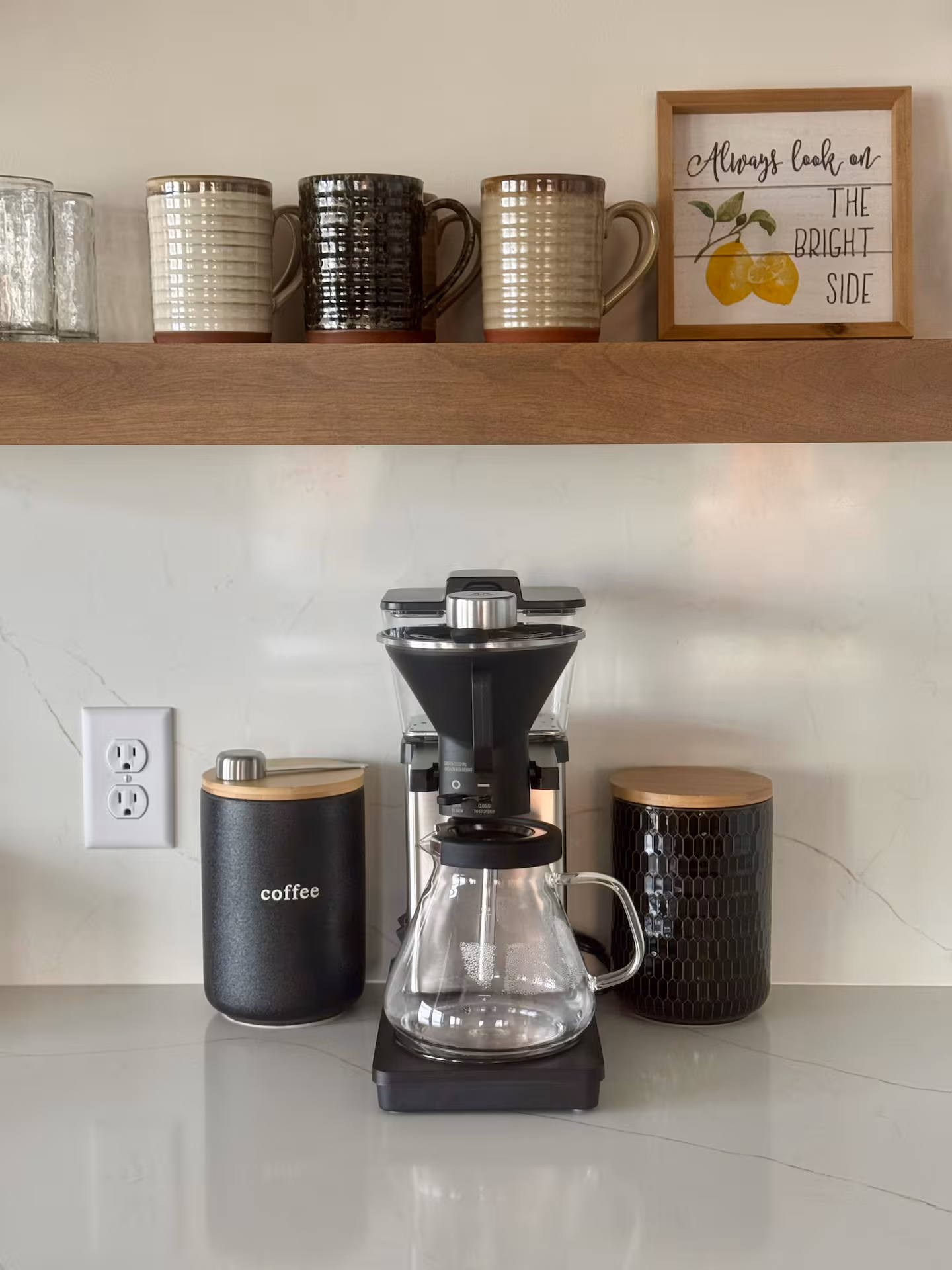 Kitchen Coffee Station with Pour-Over Setup Kitchen coffee station with pour-over coffee maker, glass carafe, mugs, and a "look on the bright side" sign