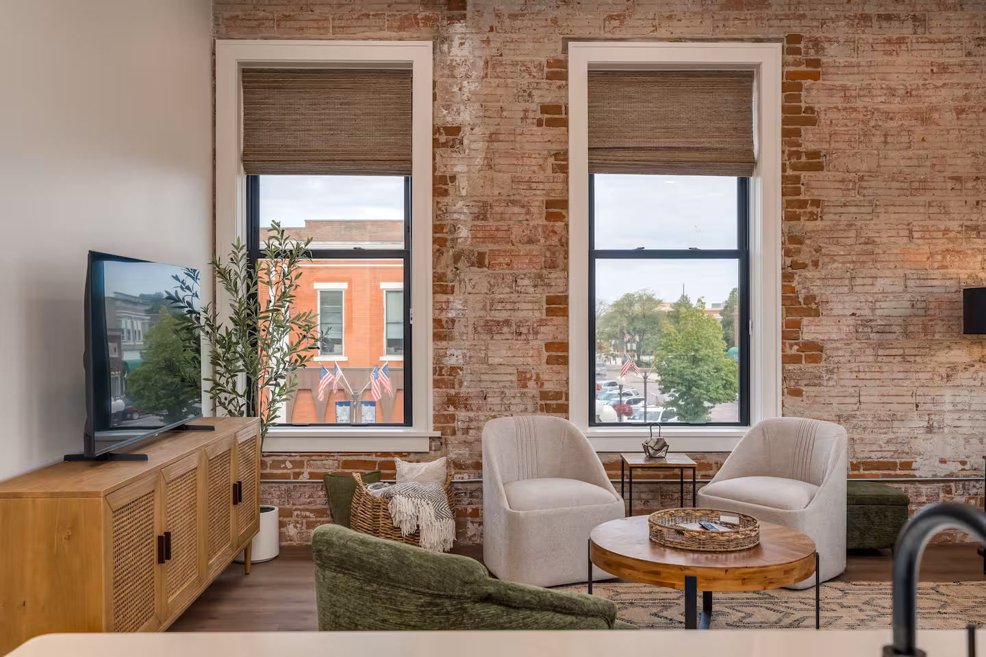 Living Room Seating Area with Downtown View Living room seating area with brick walls, tall windows, and a view of historic downtown New Ulm
